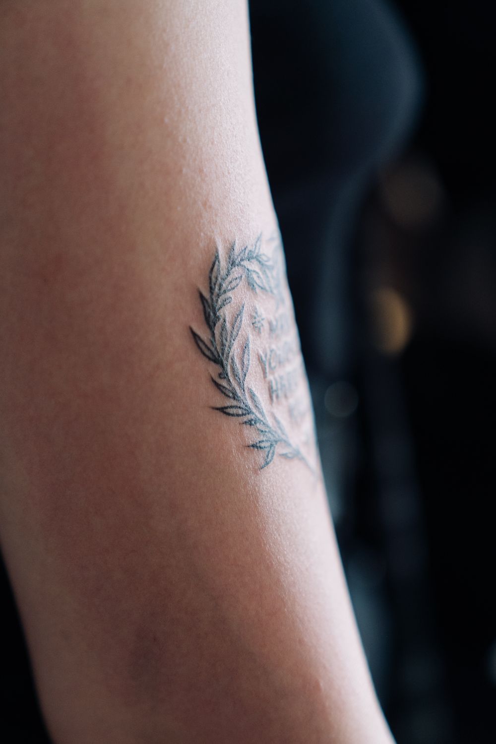 A delicate, minimal fine line tattoo on a forearm