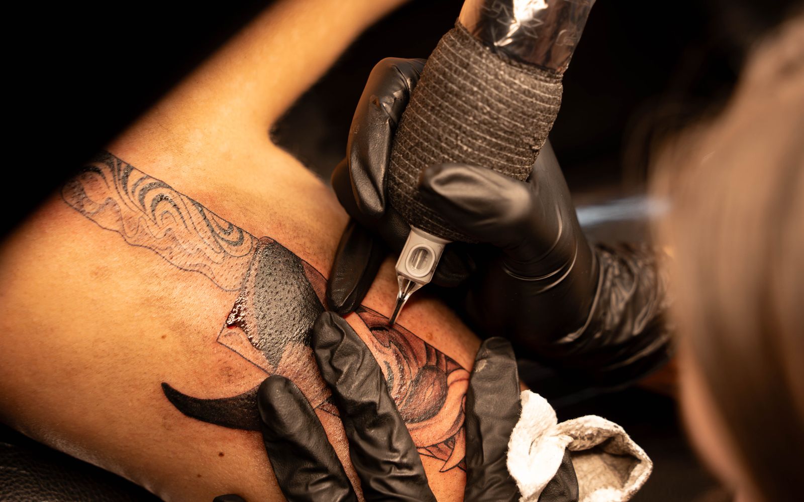 Close-up of a tattoo needle and ink during a tattoo session